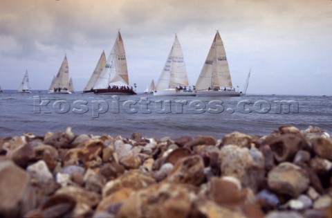Arty shot of beach and shingle and stones with Rolex Commodores Cup fleet behind