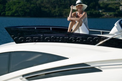 Woman sitting on the top of a powerboat wearing a straw hat
