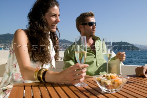 Couple sitting on a yacht drinking champagne