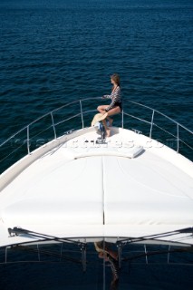 Woman sitting on the bow of a powerboat