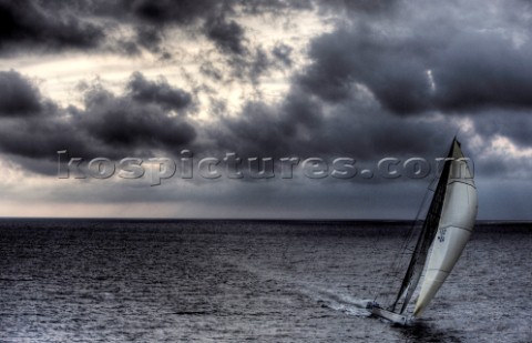 The canting keel maxi yacht Alfa Romeo offshore in a storm with clouds and stormy sky during the La 