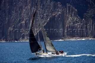 Yacht sailing in front of cliffs during the Sydney Hobart
