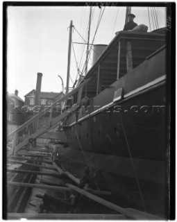 Yacht in dry dock having the hull painted in Marvins Yard on south coast UK in 1930