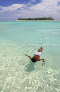A young boy plays off Honeymoon Island, Cook Islands, South Pacific.