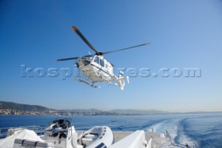 Helicopter landing on the heli deck of superyacht White Cloud
