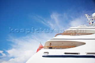 Woman leaning on railing of a superyacht and looking at view