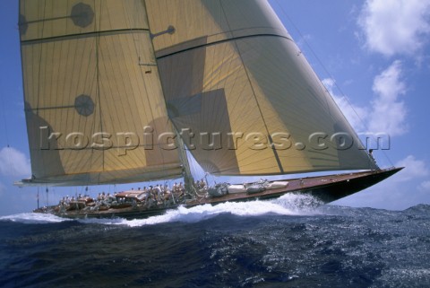 130 JClass sloop an elegant classic yachts sails in a regatta under blue sunny skies