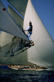 The bowman on a classic yacht uses hand signals for his skipper, while sailing in Les Voiles de St. Tropez, France.