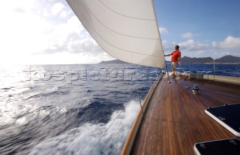A man stands on the bow of the WClass yacht Wild Horses near St Bartholomew French West Indies