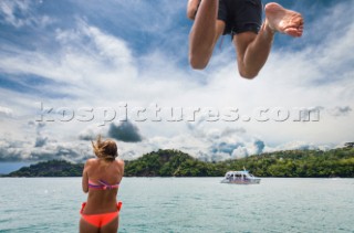A couple jumps from the roof of a boat into the ocean off the coast of Costa Rica.
