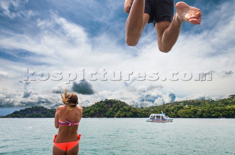 A couple jumps from the roof of a boat into the ocean off the coast of Costa Rica