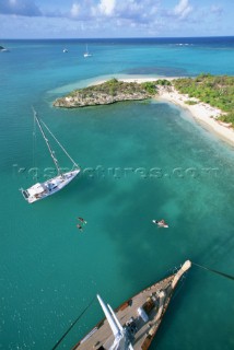 Masthead, aerial view of cruising sailboats at anchor off Green Island, Antigua, British West Indies, in the Caribbean Sea.