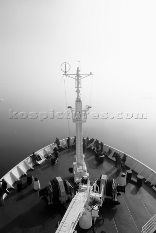 Tourists standing on the bow deck of the tourist cruise ship the Akademik Sergey Vavilov shrouded in
