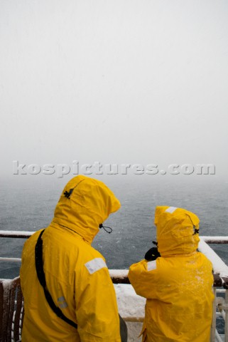 Passengers looking into thick cloud and snow while passing through the majestic Lemaire Channel Danc