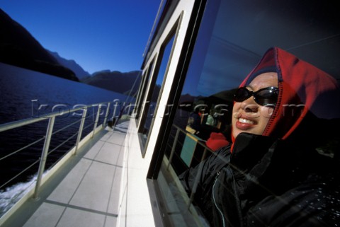 Hanh Quach looks through a viewing glass on a sightseeing boat in the Doubtful Sound Fiordland Natio