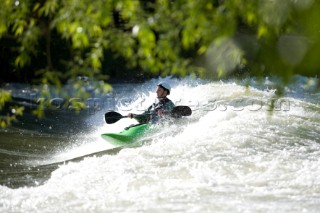 A local kayaker enjoys a kayak surfing session on the 36th Street wave in Boise Idaho. The wave is an infrequent happening, so when the wave is breaking kayakers and whitewater enthusiasts assemble for a day of riding.
