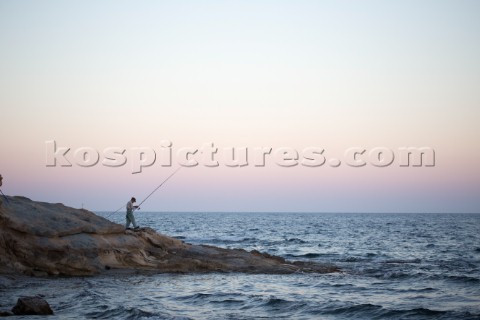 A man fishing at sunset in Calpe Alicante