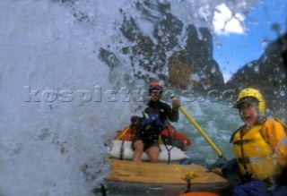 River guide and commercial client get drenched by huge wave in powerful rapids, Great Bend of Yangtze River, Yunnan Province, China.  The Great Bend is seldom rafted.  A portion of the proceeds from this trip funded an eco-tourism development project with the Nature Conservancy.