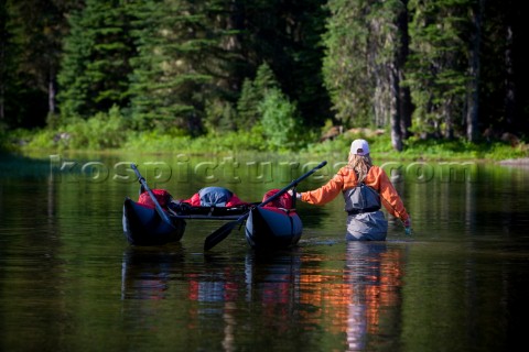 A flyfisherwoman Doreen Harper wades her pontoon boat away from the shoreline of a small lake in the