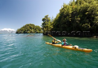 Anastacia Kampe  and Ben Sanders sea kayak during a wilderness adventure in Lago Yelcho, Chile.