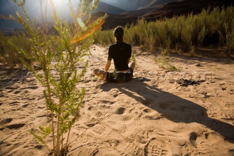 Elisa Friedman relaxing in the sand for the sunset while on a rafting trip down the Colorado River t