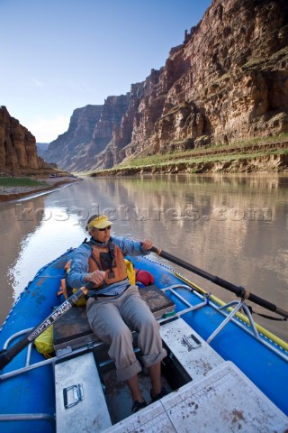 Dana Johnson paddling an inflatable raft down Cataract canyon Colorado river Utah Photo taken during