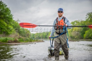 Kayak fisherman drags his boat up the Brazos River in Texas