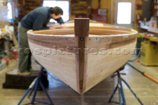 Boat builder, Alec Brainard works on the boat he is restoring at his business Artisan Boatworks in Rockport, Maine.