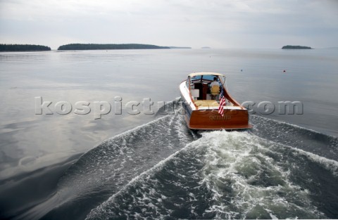 Power boat Gemma heads for home on calm seas Islands dot the horizon and lobster buoys are sprinkled