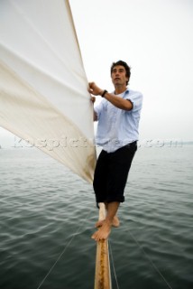 Man adjusts the sail on a sailboat, Casco Bay, Maine, New England. (releasecode: rausher and rausherPR)