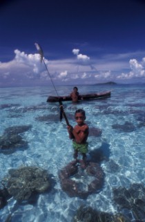 Bajau boy proudly holds speargun with  fish. Sabah/Borneo/Malaysia.