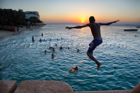 An unidentified boy jumps in the sea as the sun goes down  in the old stone town in Zanzibar Town Za