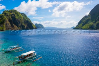 Outrigger boats anchored at Matinloc Island on the Tapiutan Strait between Tapiutan Island and Matinloc Island, El Nido, Palawan, Philippines