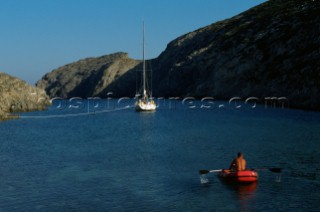 Small red rubber boat and sail boat. Joanna B. Pinneo/Aurora Photos/Kos Pictures
