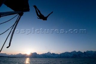 A man dives from a boat into the  Lyngen Fjord in northern Norways Lyngen Alps. Kari Medig/Aurora Photos/Kos Pictures