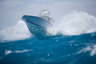 A white powerboat speeds through blue water while crashing through the waves. Chris Ross/Aurora Photos/Kos Pictures