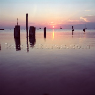 The sun sets behind sail boats as seen from the island of Caye Caulker, Belize. Karl Schatz/Aurora Photos/Kos Pictures